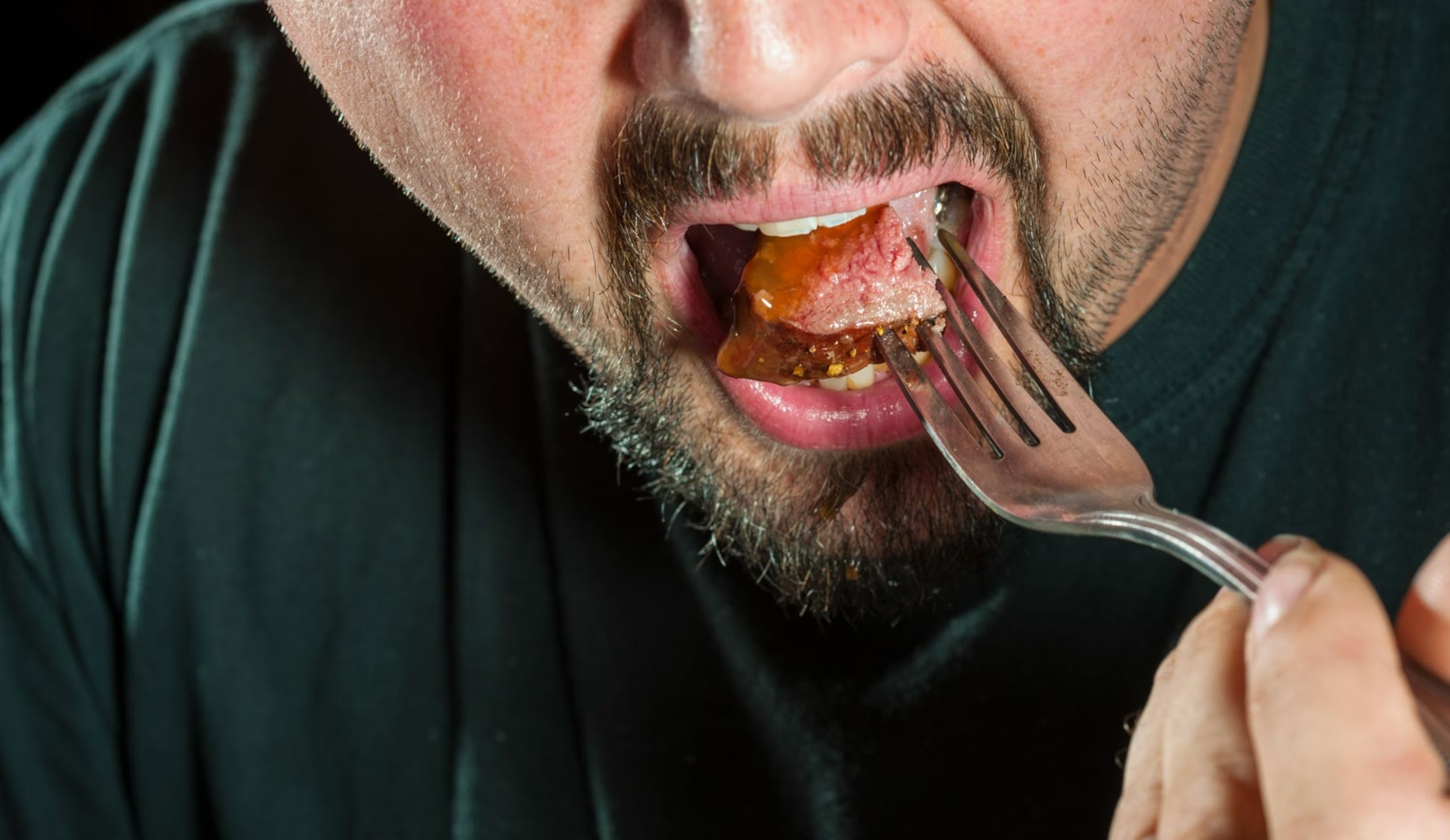 مرد در حال خوردن غذا در چنگال - درمان خانگی مسمومیت غذایی