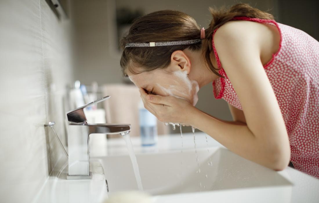 زن در حال شستشوی صورت - پاکسازی صورت با روش خانگی