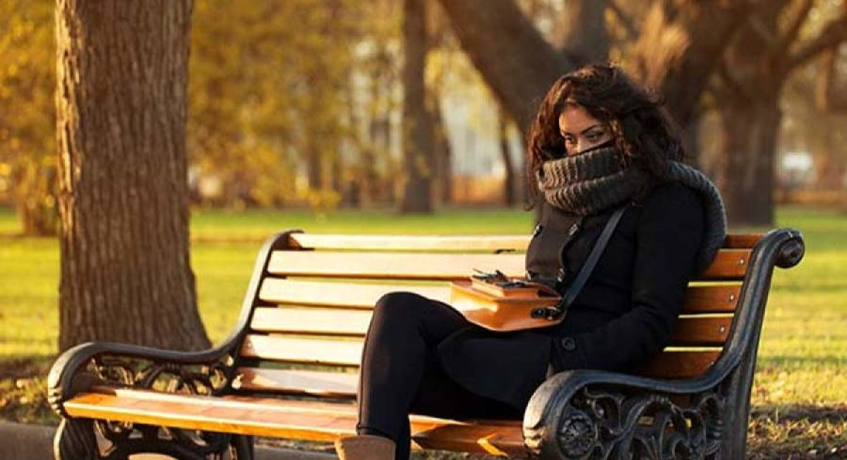 زن روی صندلی پارک نشسته - درمان افسردگی فصلی