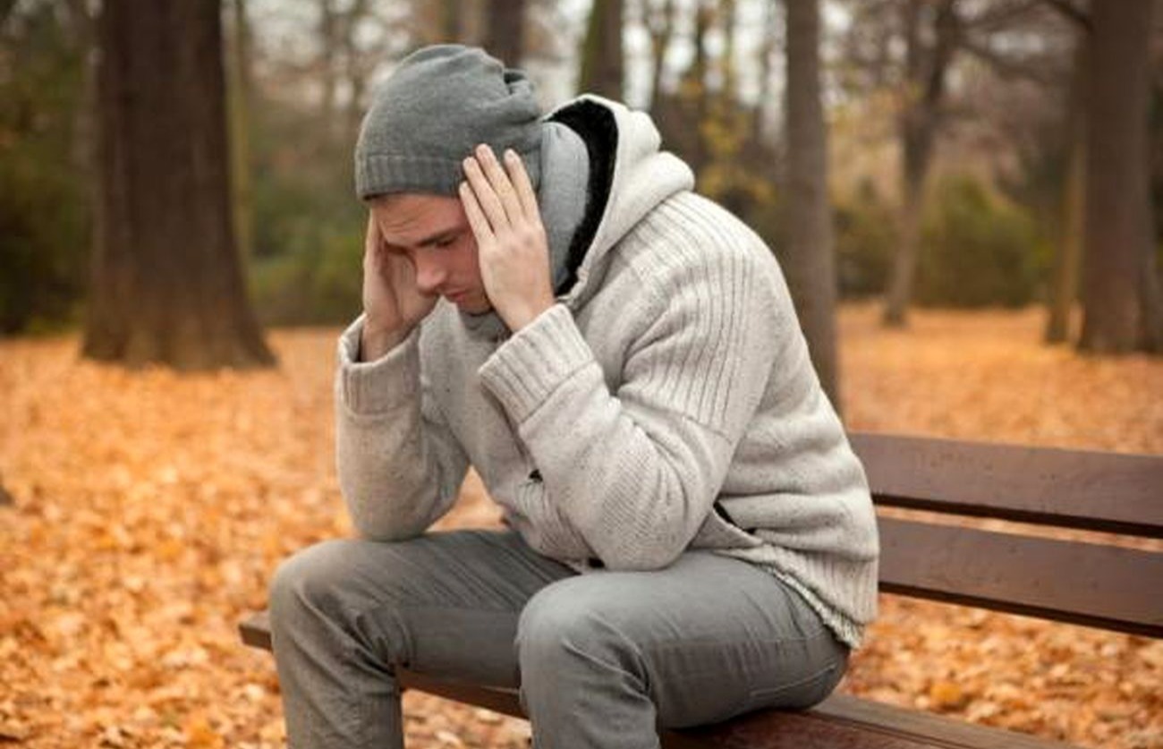 مرد روی صندلی پارک نشسته - درمان افسردگی فصلی