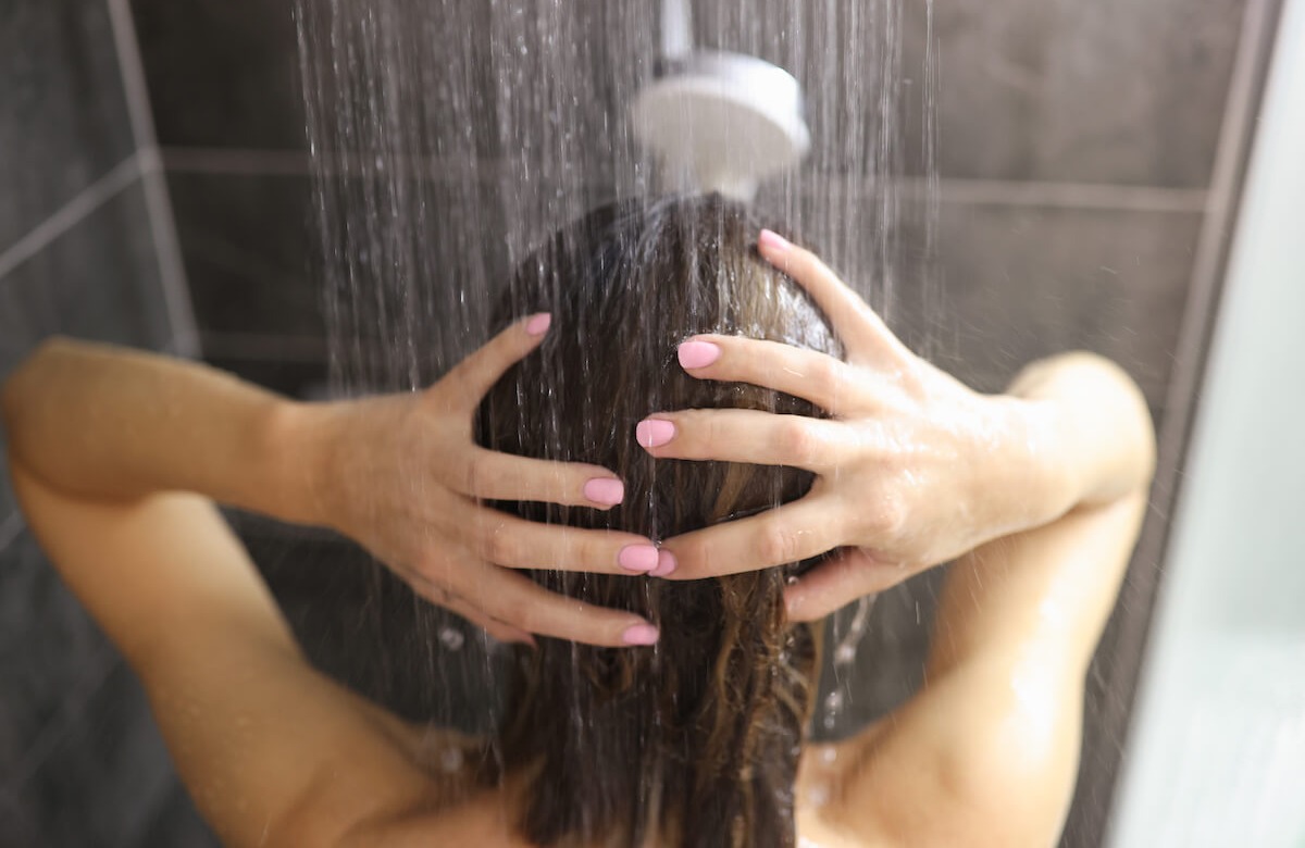 زن در حال دوش گرفتن - فواید دوش آب سرد و گرم